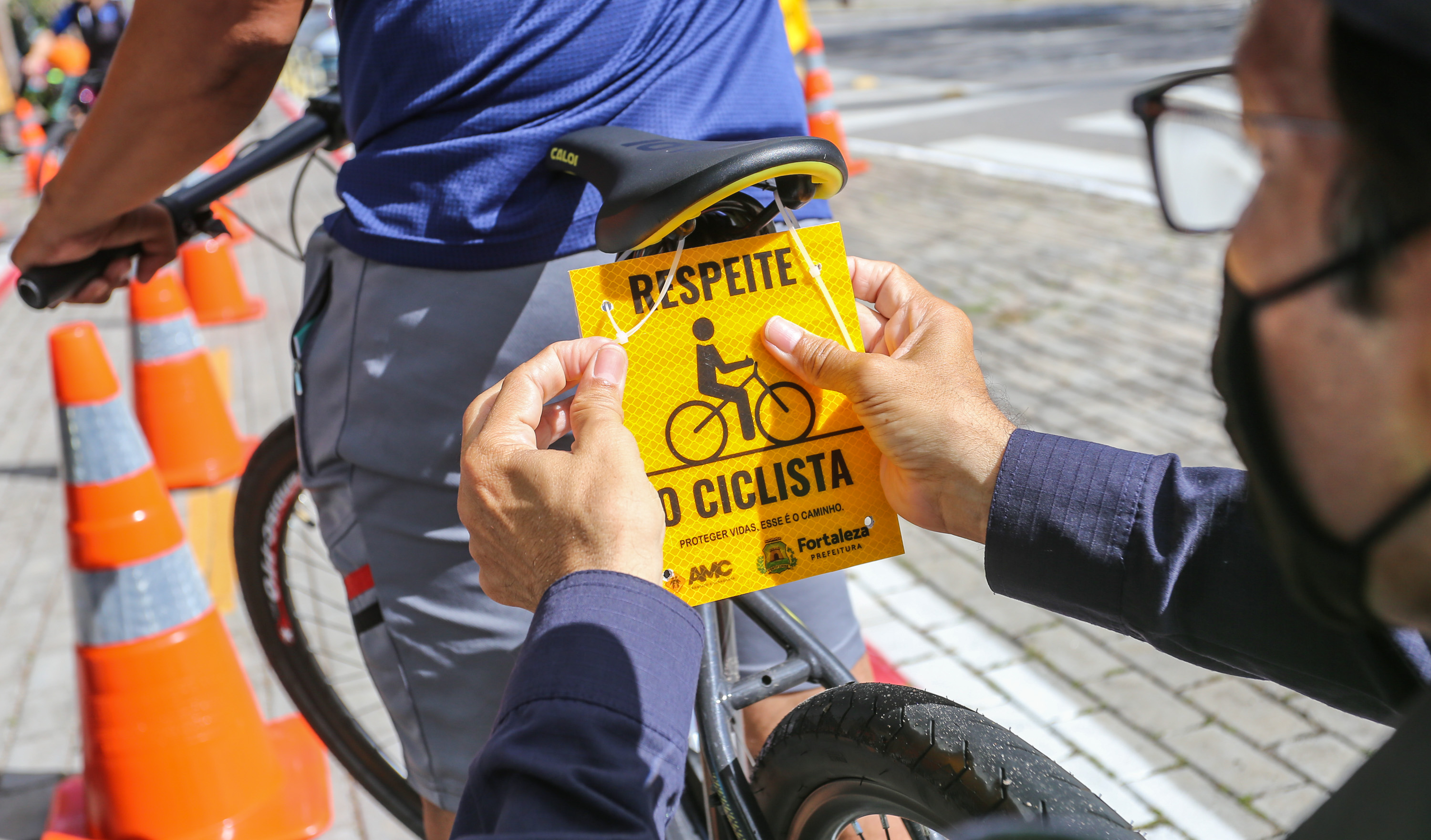 placa com a frase respeite o ciclista é coloca atrás do selim de uma bicicleta